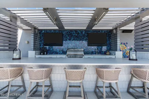 a view of a chairs and table in patio with a barbeque