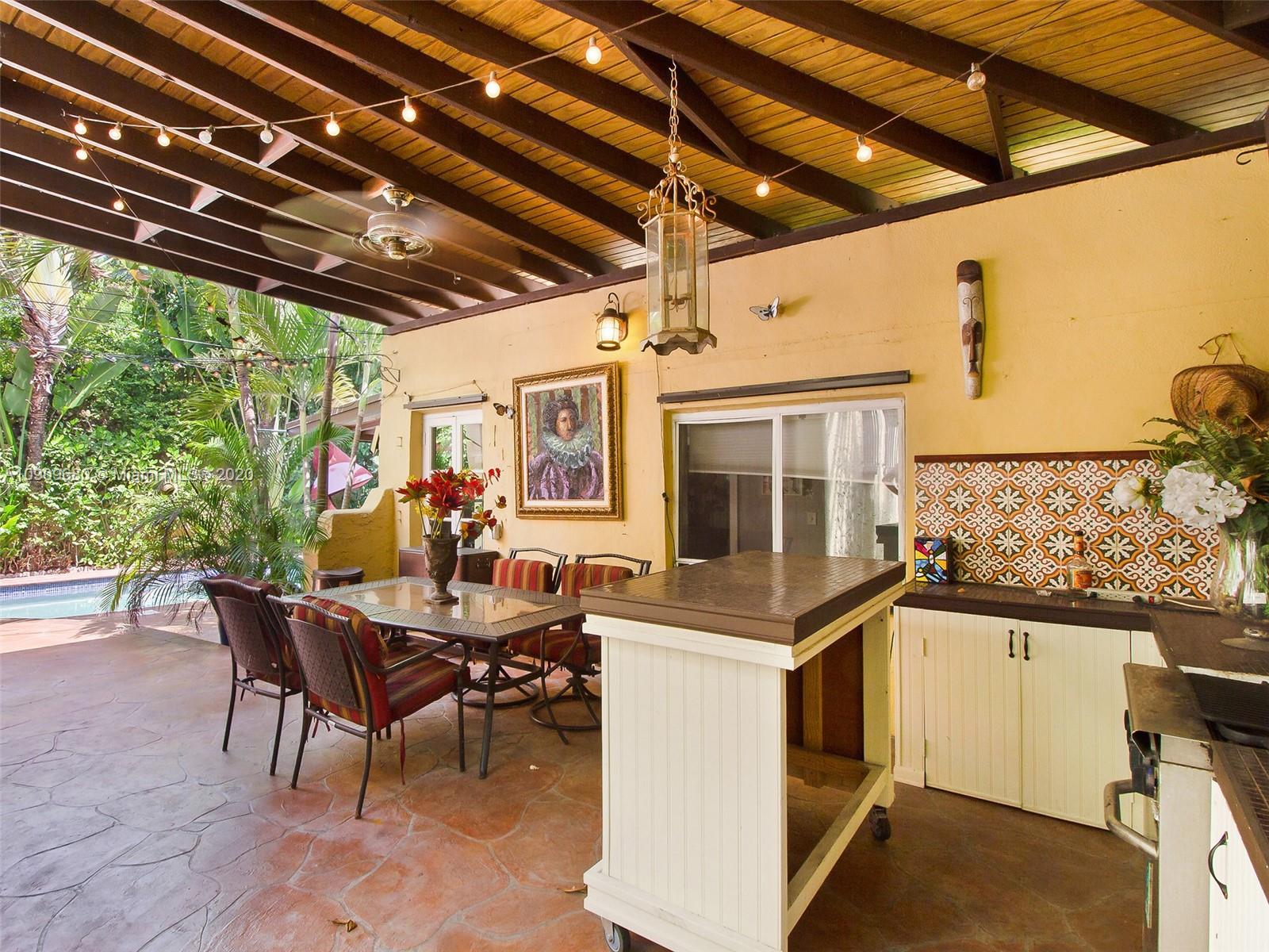 168 Northeast 44th Street Miami, FL 33137 - Photo 17 of 19 a view of a patio with table and chairs a barbeque with wooden floor and fence