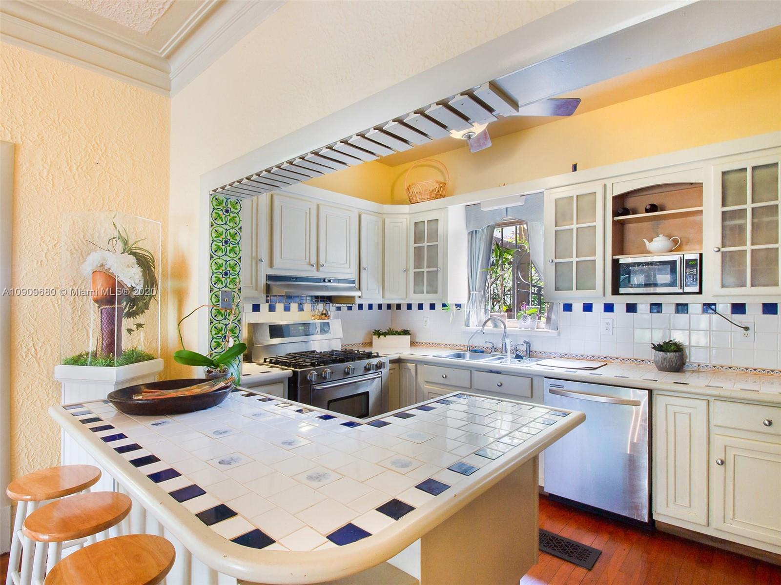 168 Northeast 44th Street Miami, FL 33137 - Photo 6 of 19 a kitchen with kitchen island a stove a sink and a refrigerator