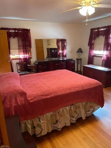 a bedroom with a bed mirror on dresser and a chandelier