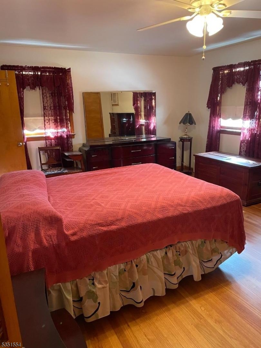 72 Baldwin Place, Unit 2 Bloomfield, NJ 07003 - Photo 11 of 14 a bedroom with a bed mirror on dresser and a chandelier