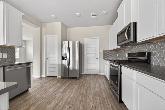 a kitchen with stainless steel appliances a refrigerator microwave and sink