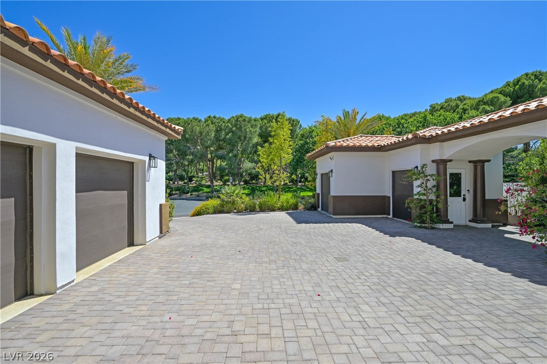 6 Rue Du Ville Henderson, NV 89011 - Photo 85 of 99 This spacious driveway leads to a charming porte-cochere and garages, all set amidst lush landscaping.
