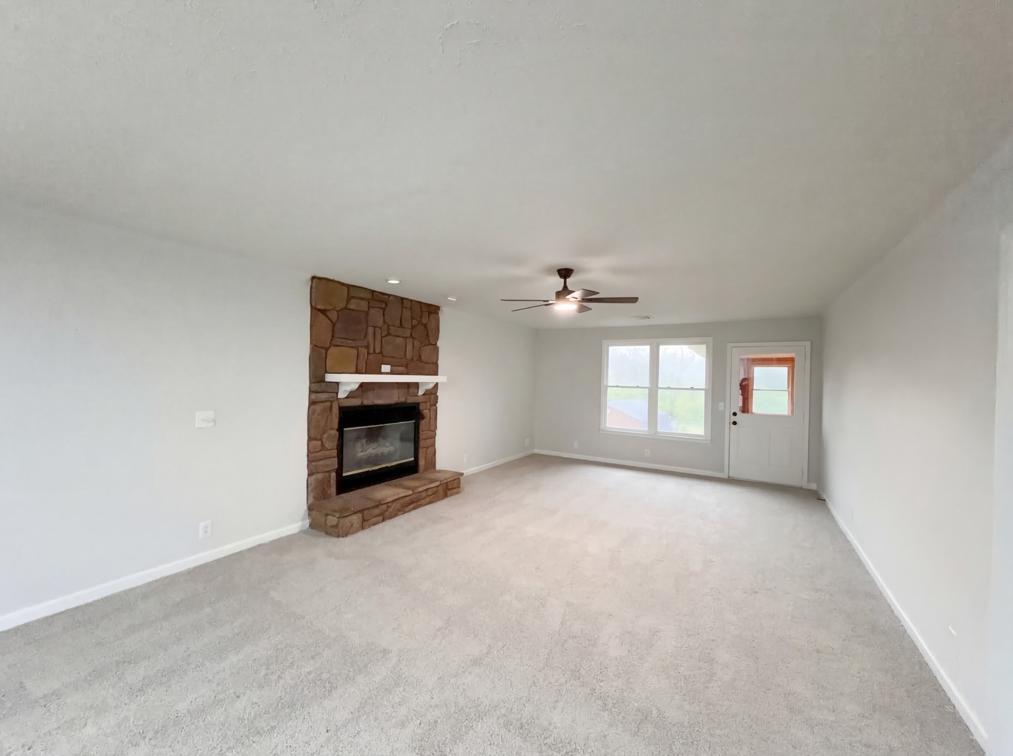 823 Apple Valley Road Madison, TN 37115 - Photo 14 of 23 an empty room with a fireplace and windows