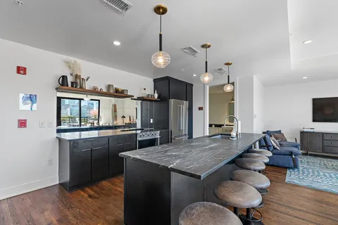 a kitchen with counter top space and wooden floor