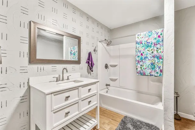 a bathroom with a bath tub a sink and a mirror