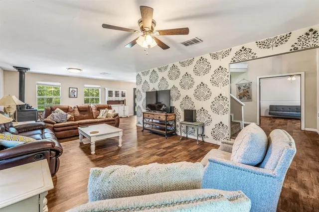 a living room with furniture kitchen view and a flat screen tv