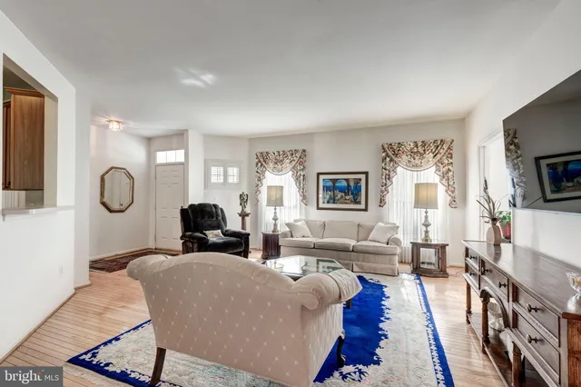 a living room with furniture a flat screen tv and a large mirror