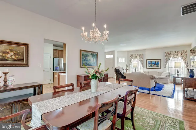 a view of a dining room with furniture a chandelier and wooden floor