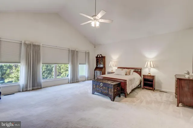 a bed sitting in a spacious bedroom next to a window