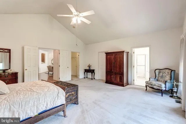 a spacious bedroom with a bed a desk and chair
