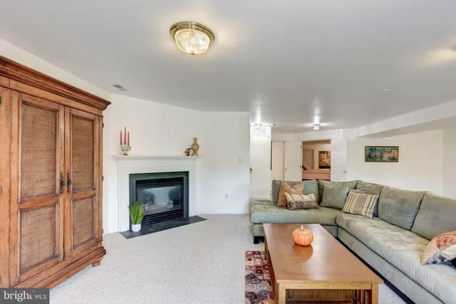 a living room with furniture a fireplace and a window