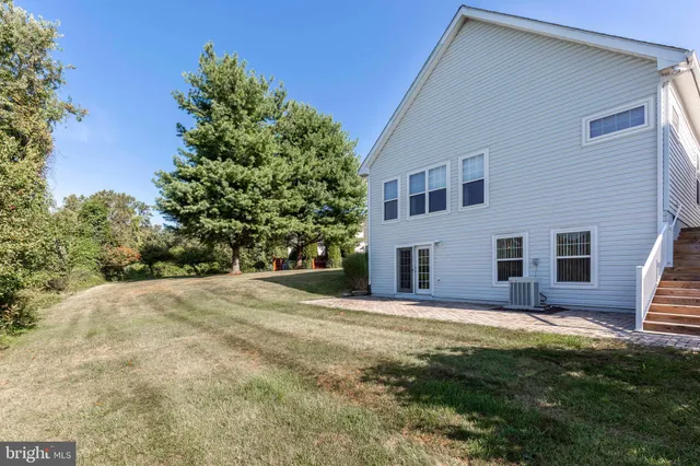a view of house with yard and trees in the background