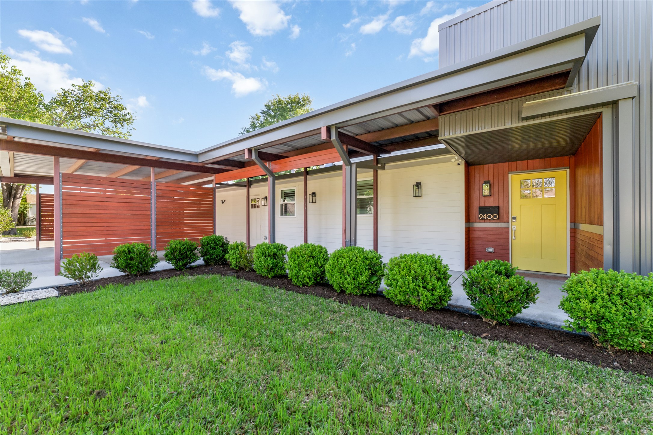 9400 Spring Branch Drive Houston, TX 77080 - Photo 1 of 45 Modern architectural gem featuring a sleek facade with bold lines, a stylish yellow door, and lush landscaping, offering a welcoming and contemporary entrance.