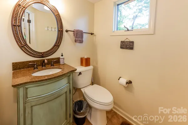a bathroom with a granite countertop toilet sink and mirror