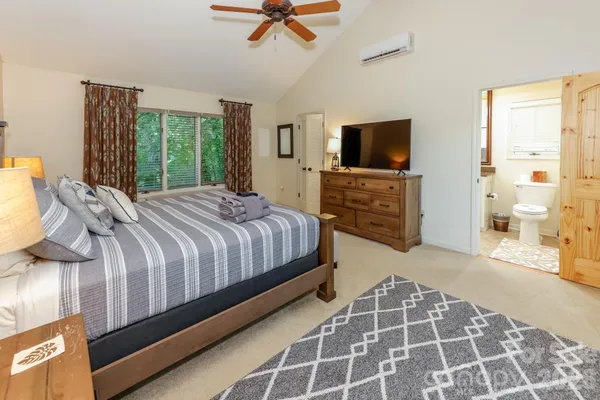 a bedroom with a large bed and a flat screen tv