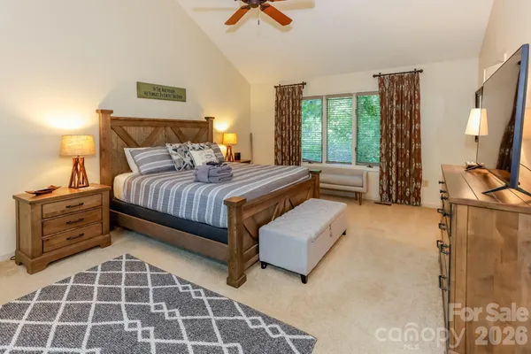 a bedroom with a bed and a flat tv screen on the dresser
