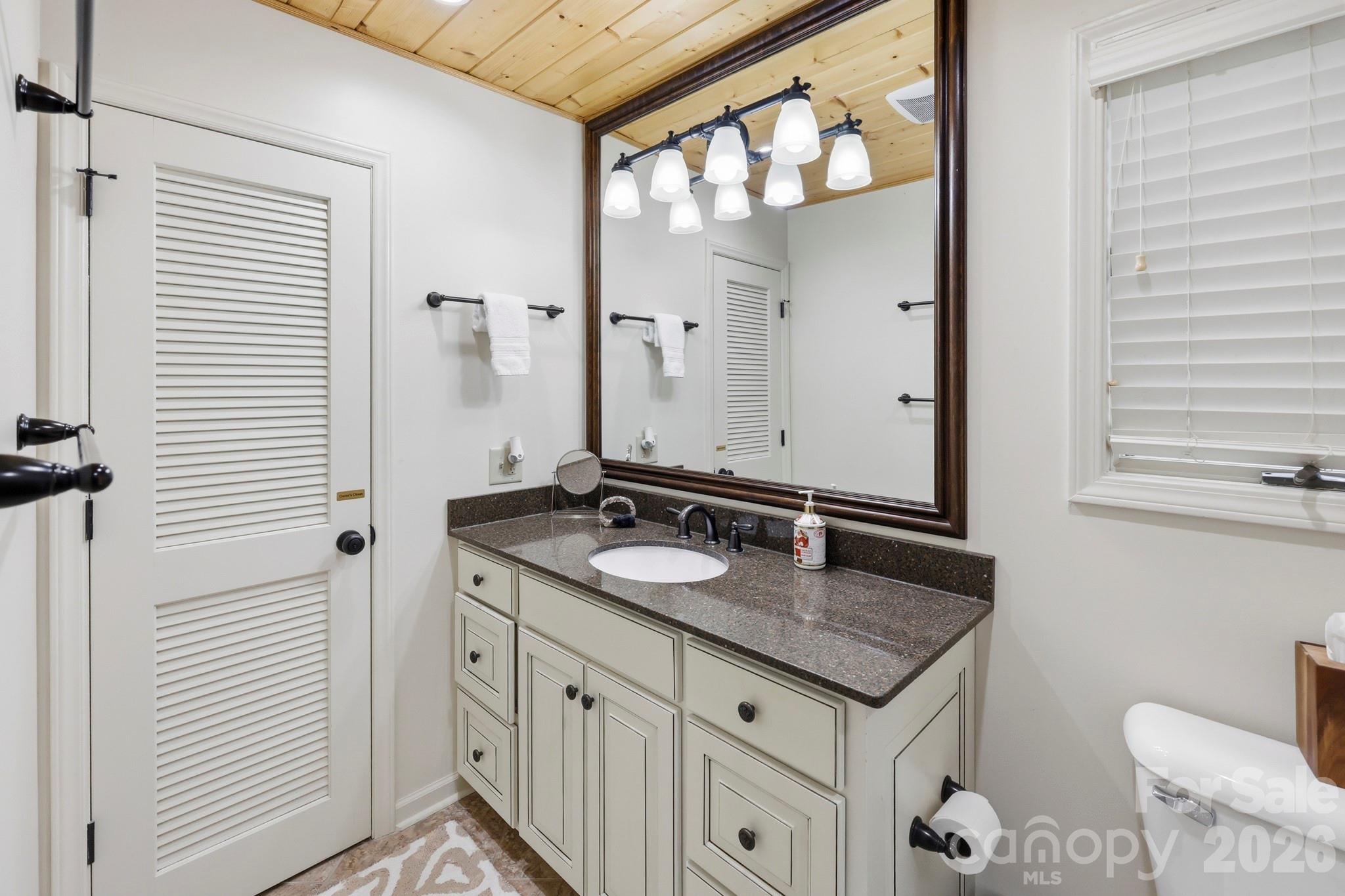 130 Edwards Point Lake Lure, NC 28746 - Photo 18 of 35 a bathroom with a granite countertop sink and a mirror