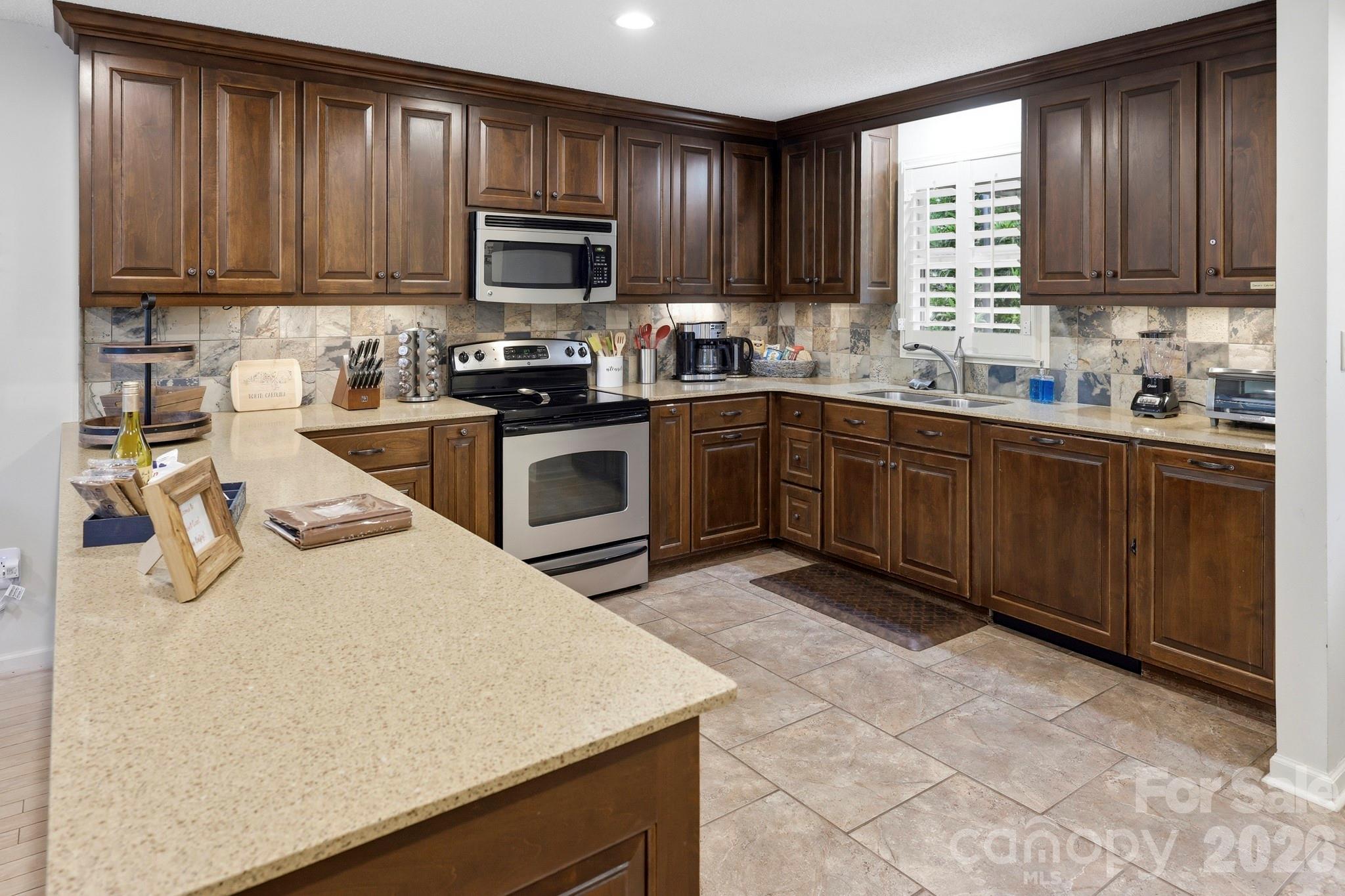 130 Edwards Point Lake Lure, NC 28746 - Photo 10 of 35 a kitchen with granite countertop wooden cabinets a stove top oven a sink and dishwasher