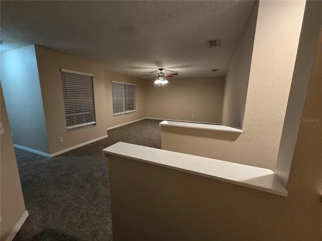 an empty room with a ceiling fan and a window