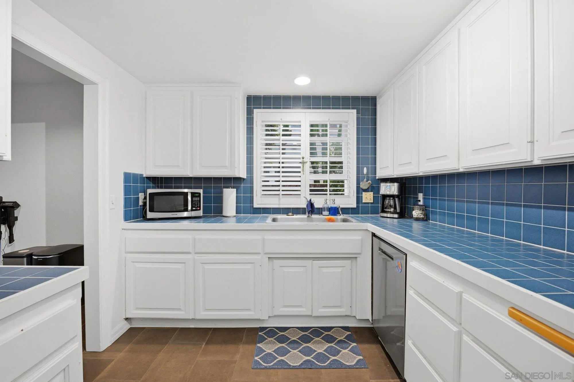 711 Kline Street, Unit A La Jolla, CA 92037 - Photo 8 of 20 a kitchen with stainless steel appliances white cabinets and a sink