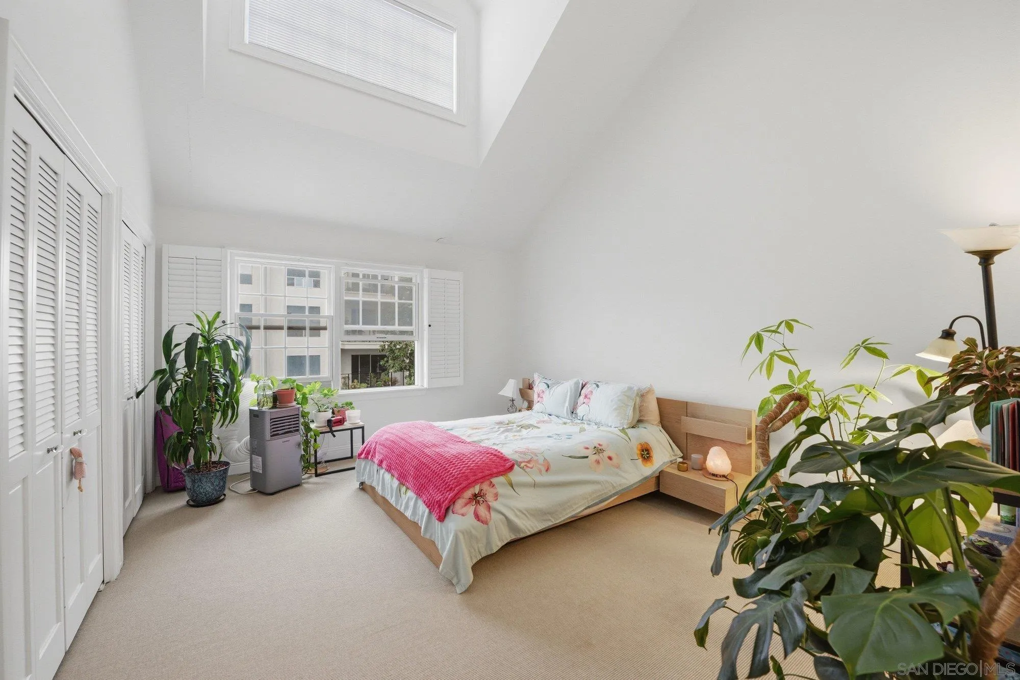 711 Kline Street, Unit A La Jolla, CA 92037 - Photo 10 of 20 a bedroom with a bed table and a potted plant