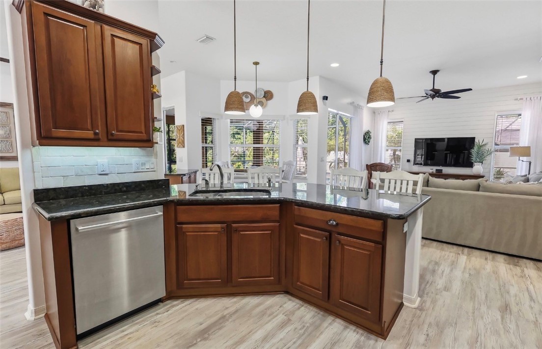 1771 Mistletoe Street Sebastian, FL 32958 - Photo 10 of 36 a kitchen with stainless steel appliances granite countertop a sink a stove and a wooden floors
