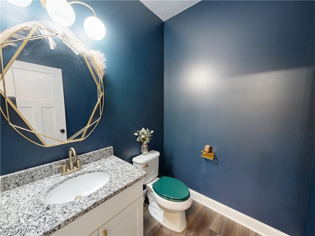 37328 Sandy Ridge Drive North Ridgeville, OH 44039 - Photo 19 of 39 Bathroom featuring wood finished floors, toilet, vanity, and baseboards