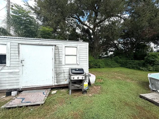 a backyard of a house with yard table and chairs