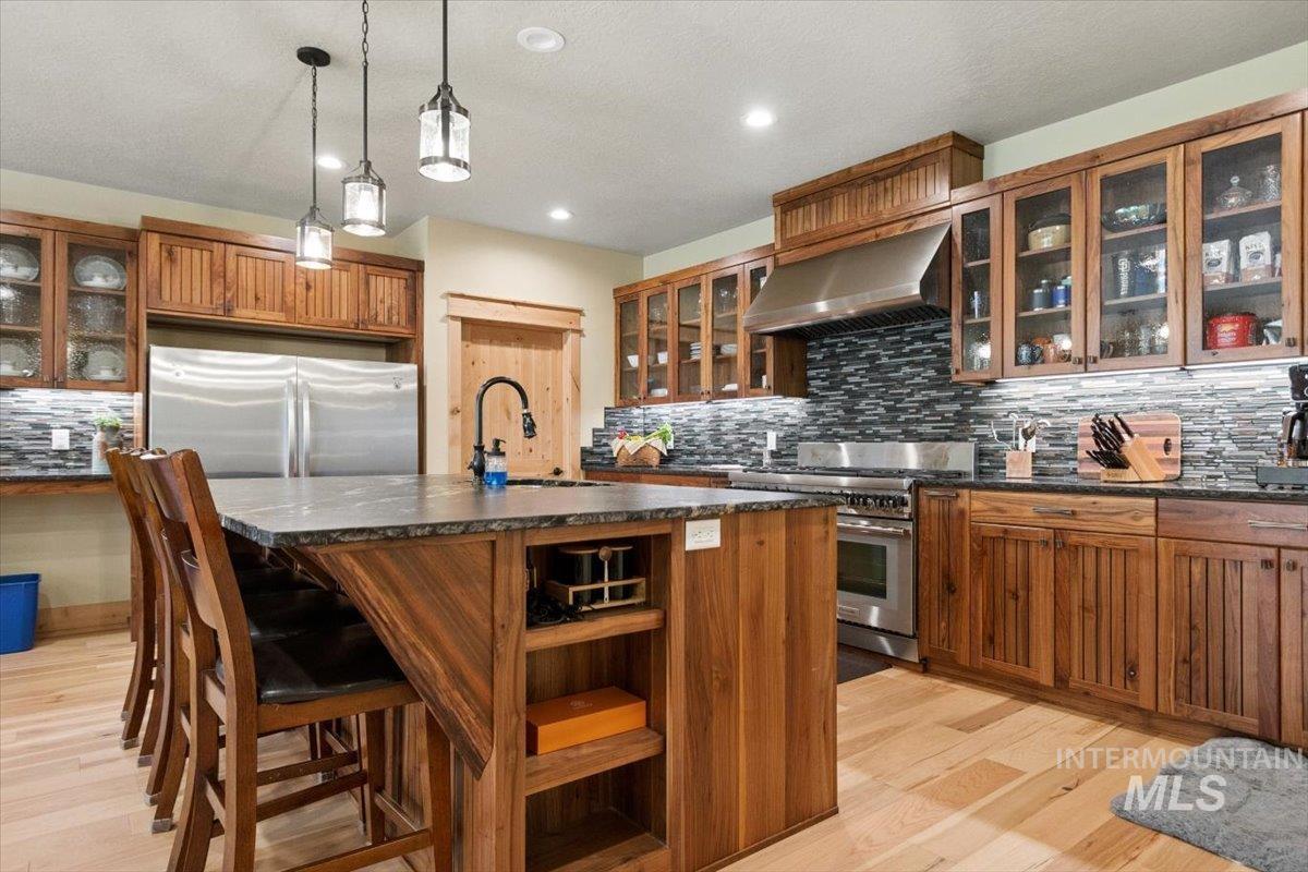 36 Kevins Way Garden Valley, ID 83622 - Photo 14 of 50 Kitchen featuring stainless steel appliances, range hood, wood finish cabinetry, and glass insert cabinets