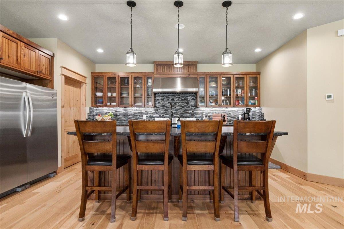 36 Kevins Way Garden Valley, ID 83622 - Photo 15 of 50 Kitchen with glass fronted cabinets, stainless steel appliances, pendant lighting, and light wood finished floors