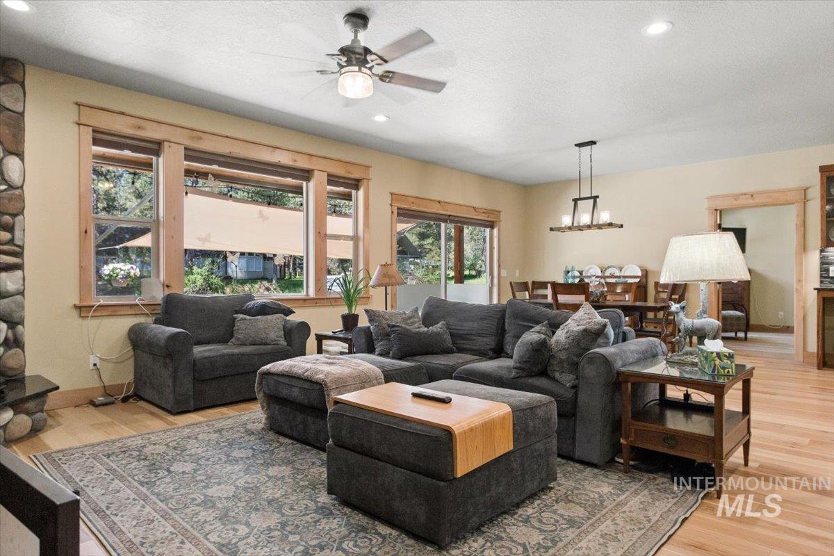36 Kevins Way Garden Valley, ID 83622 - Photo 18 of 50 Dining room with light wood-type flooring, a textured ceiling, a ceiling fan, and a fireplace