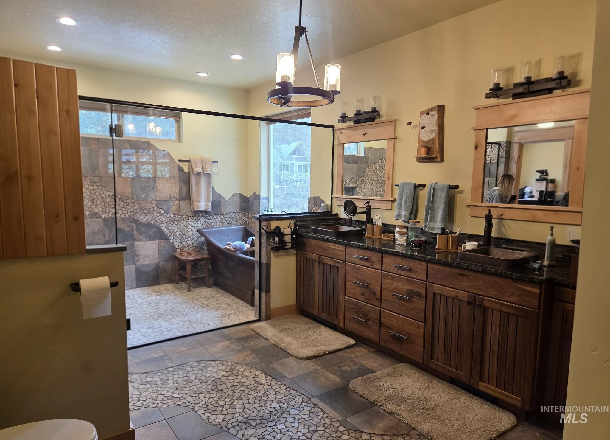 36 Kevins Way Garden Valley, ID 83622 - Photo 18 of 50 Full bath with double vanity, a stall shower, a chandelier, stone tile floors, and a bathtub