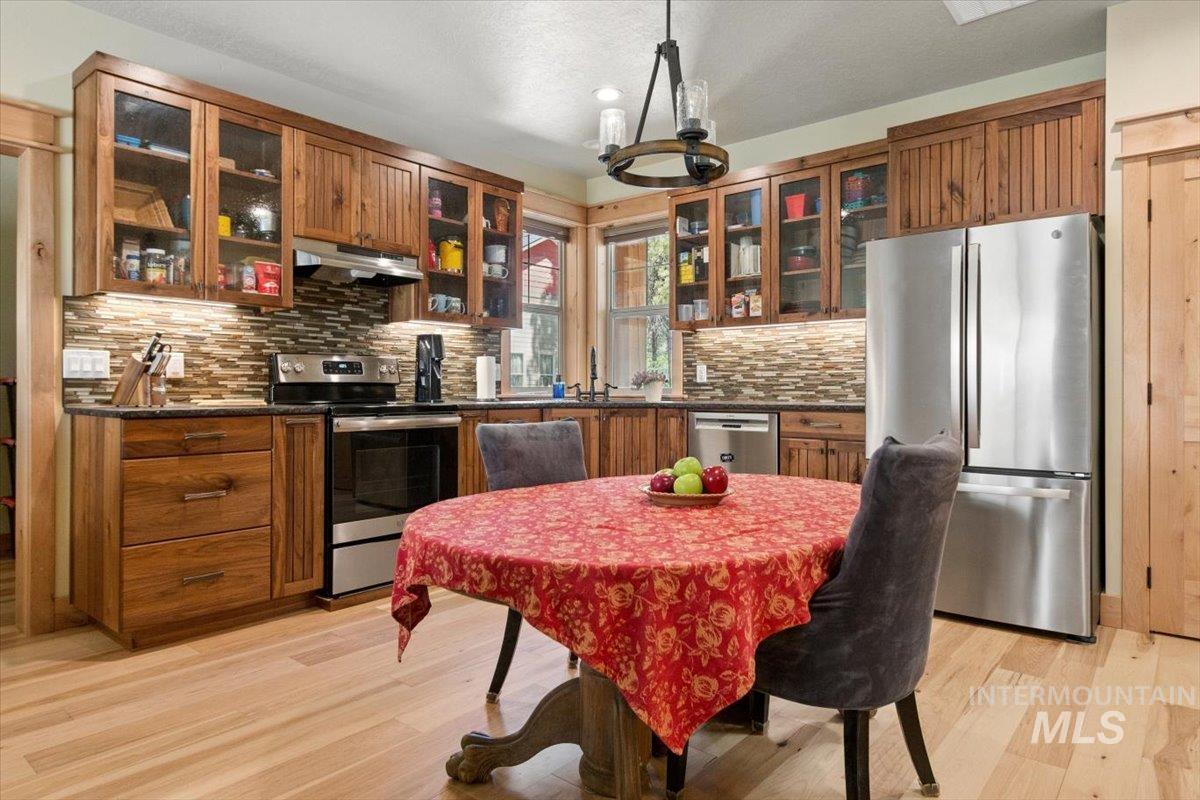 36 Kevins Way Garden Valley, ID 83622 - Photo 27 of 50 Apartment Kitchen featuring backsplash, stainless steel appliances, glass insert cabinets, and under cabinet range hood
