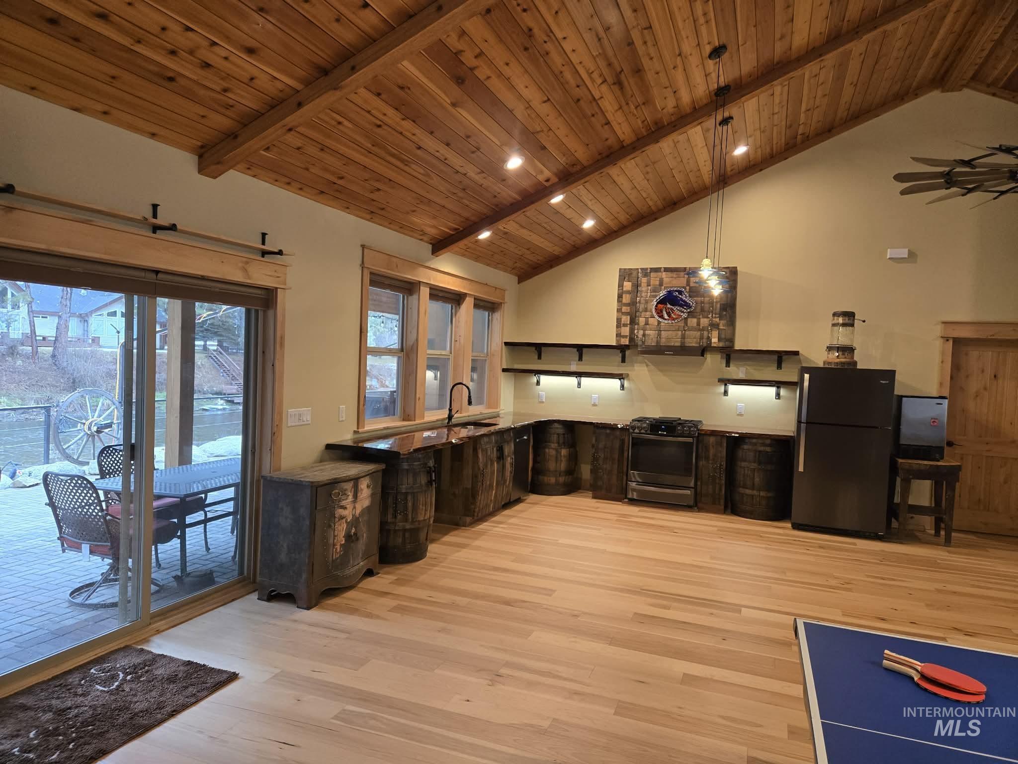 36 Kevins Way Garden Valley, ID 83622 - Photo 28 of 50 Kitchen featuring a high wooden beamed ceiling, stainless steel range with gas stovetop, light wood-style floors, freestanding refrigerator, and decorative light fixtures