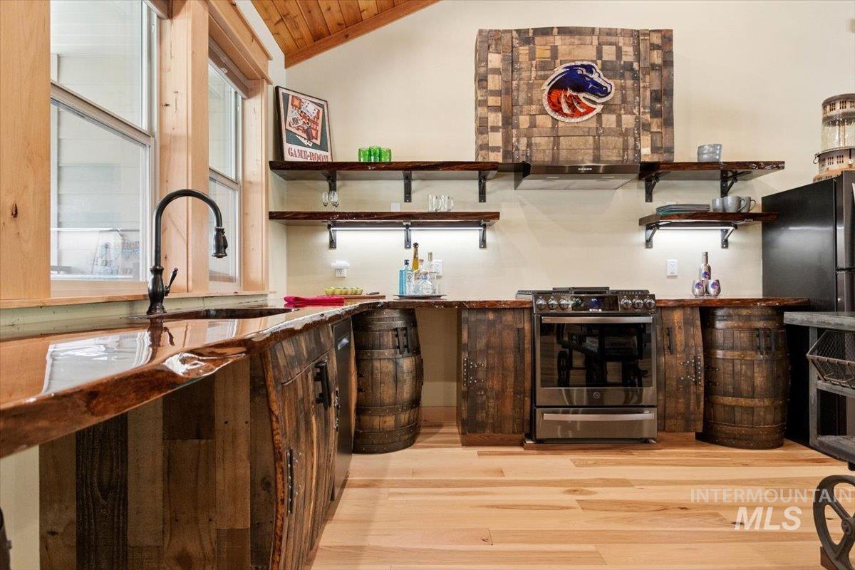 36 Kevins Way Garden Valley, ID 83622 - Photo 32 of 50 Kitchen featuring a high wooden beamed ceiling, stainless steel range with gas stovetop, light wood-style floors, freestanding refrigerator, and decorative light fixtures