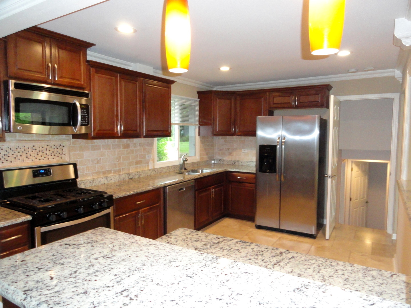 596 Maple Avenue Lisle, IL 60532 - Photo 3 of 21 a kitchen with granite countertop a stove a microwave and refrigerator