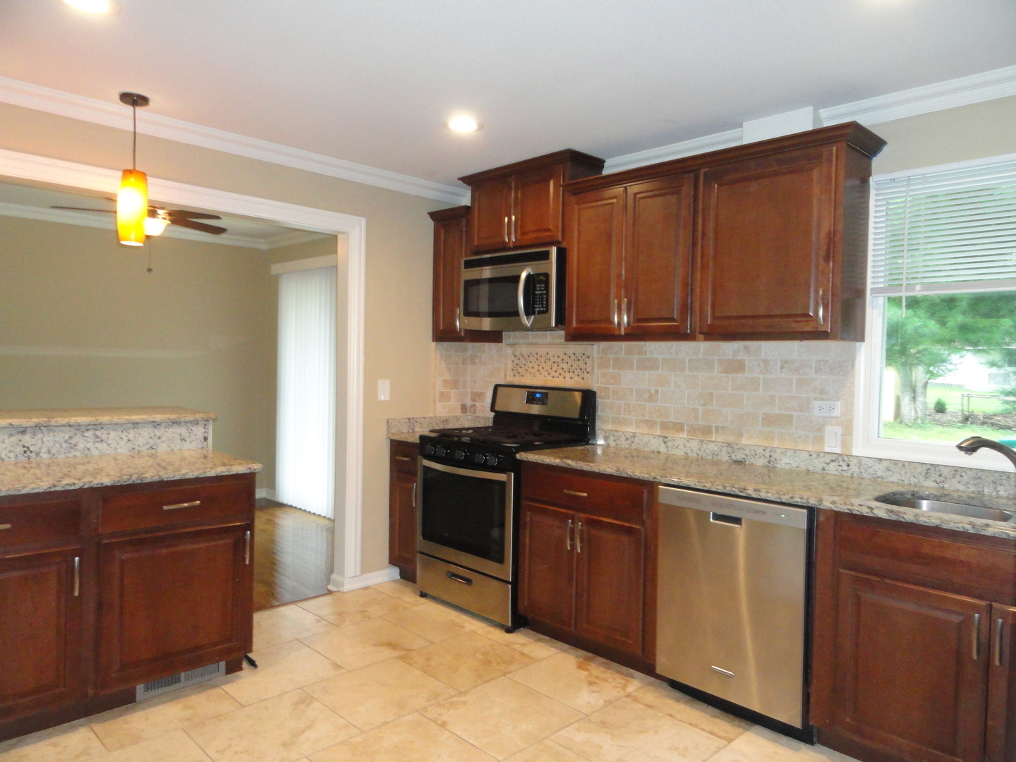 596 Maple Avenue Lisle, IL 60532 - Photo 4 of 21 a kitchen with granite countertop stainless steel appliances a stove sink and microwave