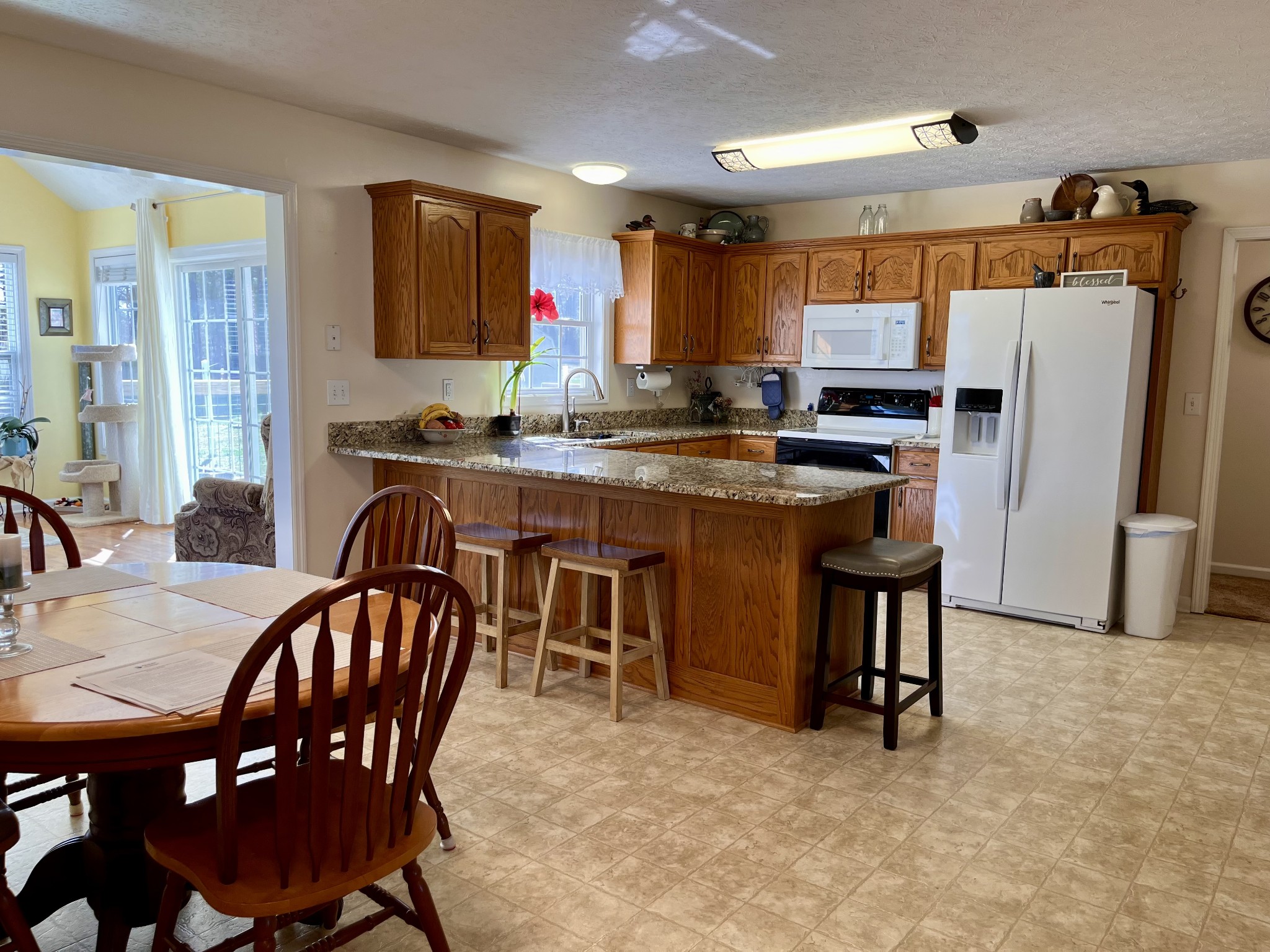 4869 Starks Road Cross Plains, TN 37049 - Photo 11 of 46 a kitchen with stainless steel appliances granite countertop a stove a refrigerator a kitchen island and chairs