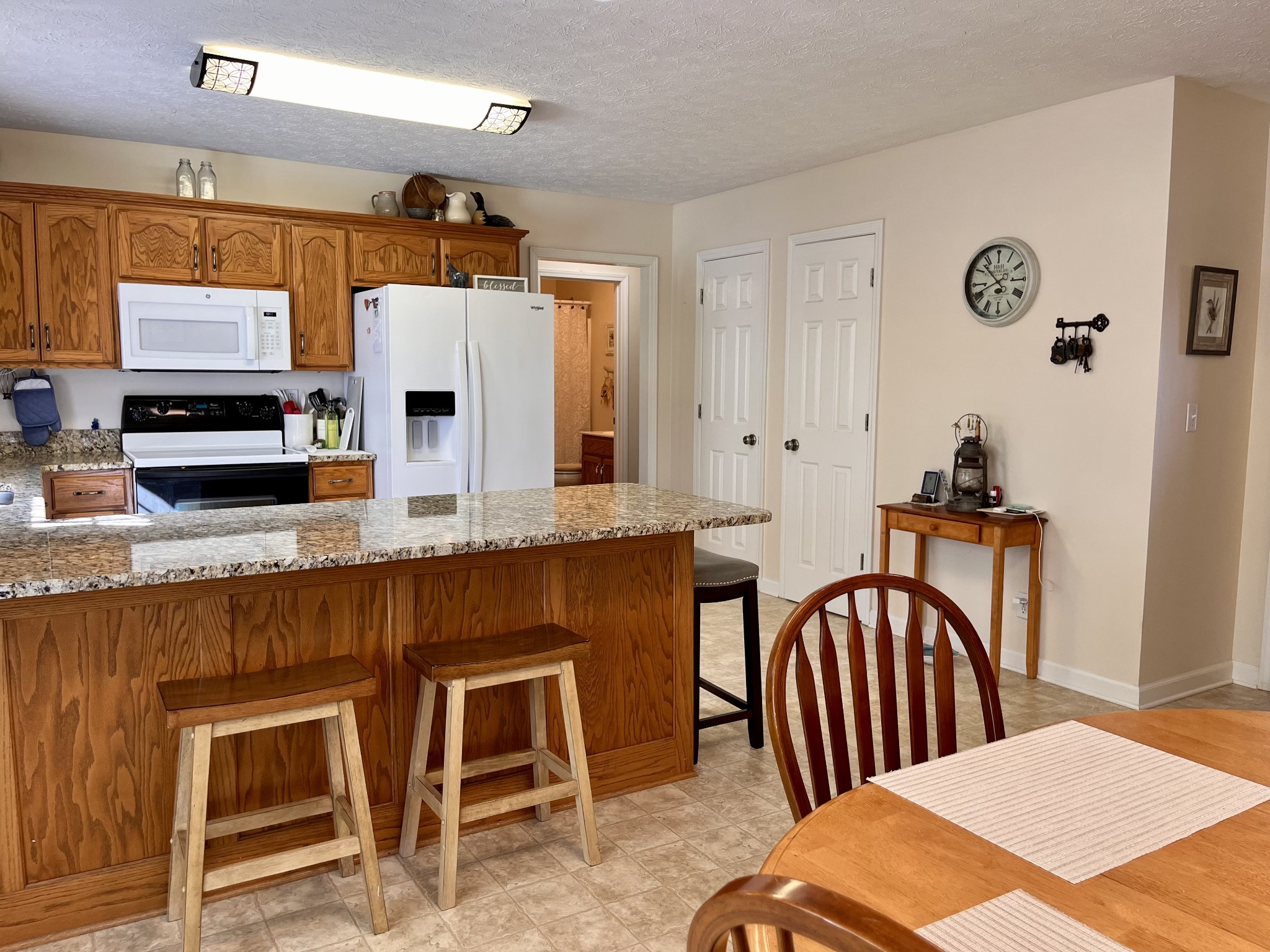 4869 Starks Road Cross Plains, TN 37049 - Photo 12 of 46 a kitchen with stainless steel appliances granite countertop a stove a sink dishwasher and wooden cabinets with wooden floor