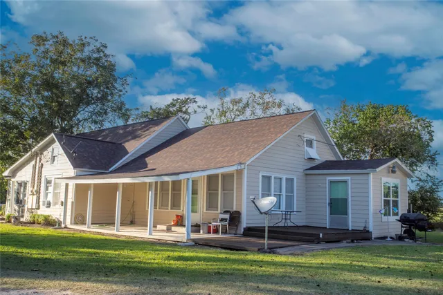 a front view of a house with a garden and trees