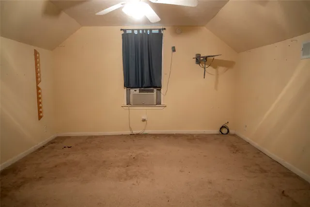 an empty room with a ceiling fan and a window