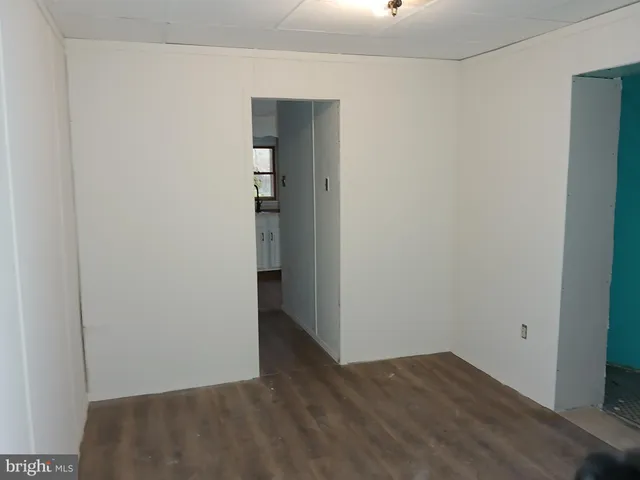 an empty room with wooden floor and closet