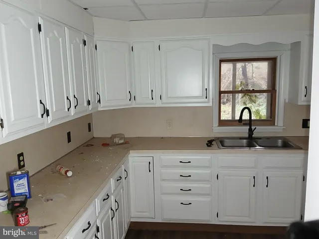a kitchen with granite countertop white cabinets and window
