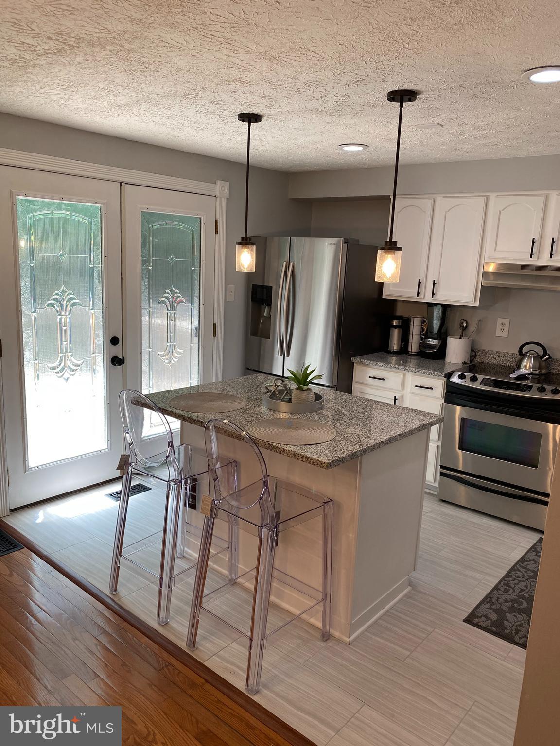 7 Capland Court Perry Hall, MD 21128 - Photo 2 of 7 a kitchen with kitchen island granite countertop a stove a sink a refrigerator dining table and chairs