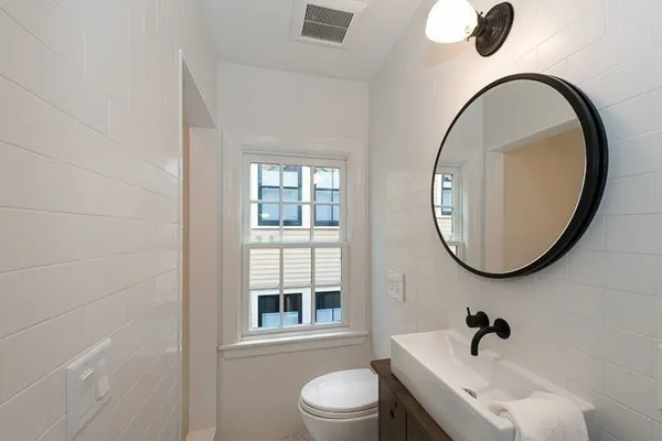 a bathroom with a toilet a sink and a mirror