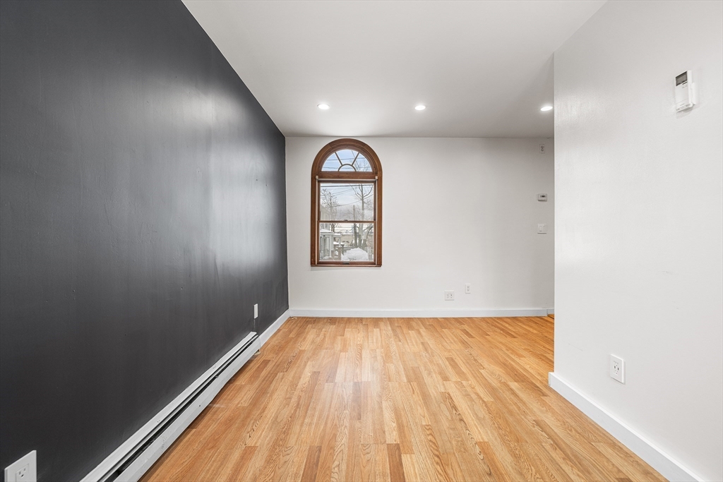34 Paris Street Everett, MA 02149 - Photo 12 of 25 an empty room with wooden floor and windows