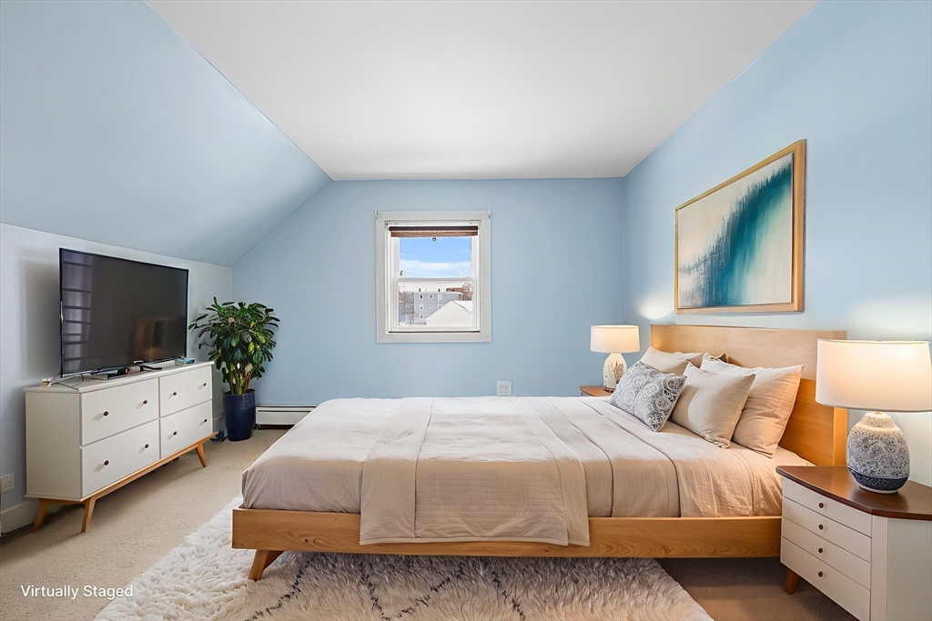 34 Paris Street Everett, MA 02149 - Photo 17 of 25 a bedroom with a bed and a flat screen tv