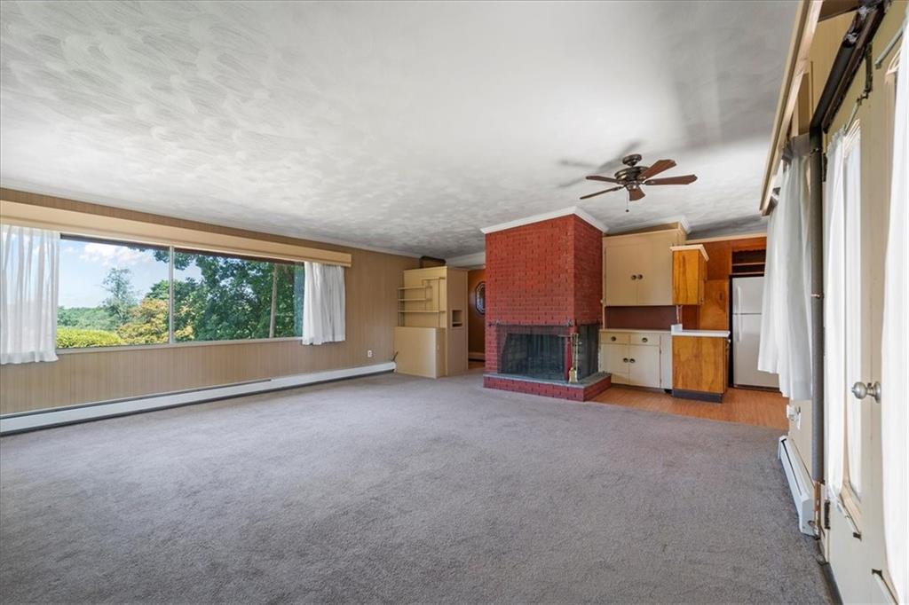 1143 Altman Road Jeannette, PA 15644 - Photo 29 of 50 an empty room with a fireplace and chandelier