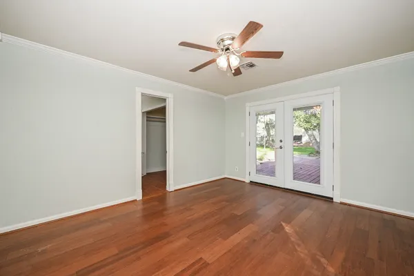 a view of an empty room with window and wooden floor